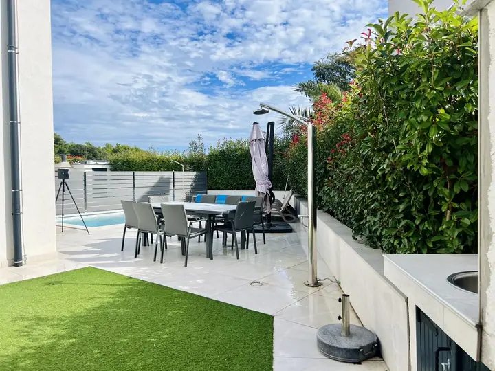 Gartenterrasse mit Esstisch und Außenküche